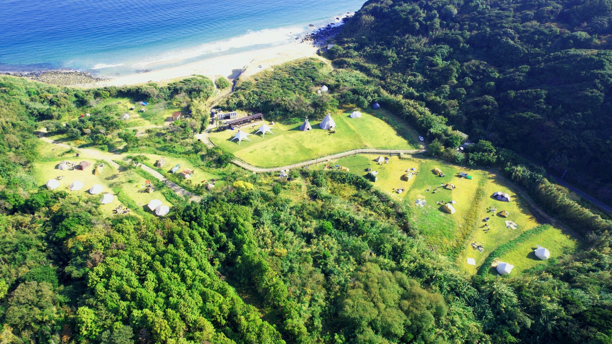 Wide overhead view of Karadomari Village grounds, coastline, and retreat layout
